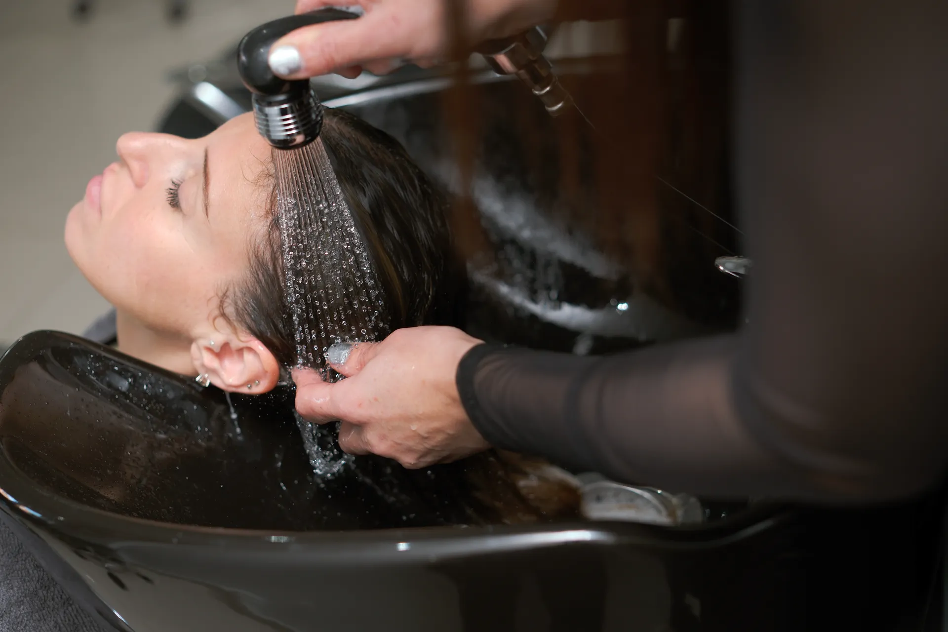 A client's hair is rinsed in a salon basin.